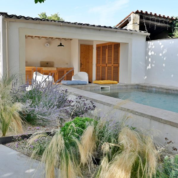 Au fond de ce jardin de 125 m2, le pool-house abrite une jolie cuisine d'été en bois