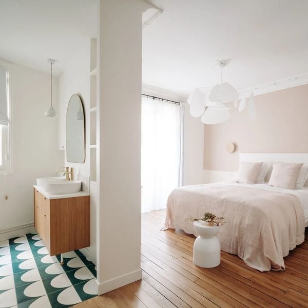 La salle de bains ouverte sur la chambre s'amuse avec un univers contrasté pour une double pièce de caractère