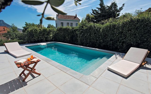 Piscine 6 x 3 rectangulaire, GRI 181, escalier sous liner, margelle classic ton gris, liner gris : à partir de 25 000 euros. (*Prix à partir de correspondant à la fourniture d'une piscine, hors pose, hors transport). Desjoyaux.