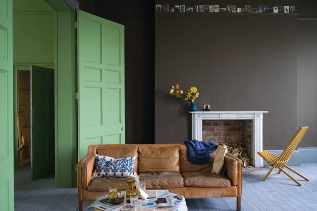 Dans ce séjour, le brun des murs est égayé par le vert pétillant des boiseries. Le tout associé à un sol de couleur gris clair, la pièce est accueillante et réchauffée. En photo : Peinture Salon Darb 290 sur les murs, Peinture Yeabridge Green 287sur les boiseries, à partir de 73,50 euros pour 2,5L, Farrow & Ball.