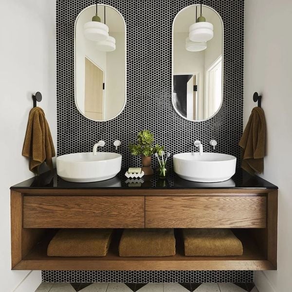 Une mosaïque noire couvre tout un pan de mur de la salle de bains