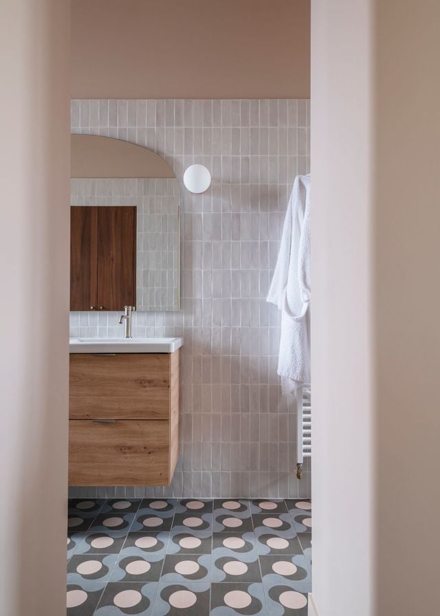Depuis l'entrée de la salle de bains, un jeu entre les courbes et les lignes révèle une salle de bains à la symétrie parfaite. Réalisation Maison Sama