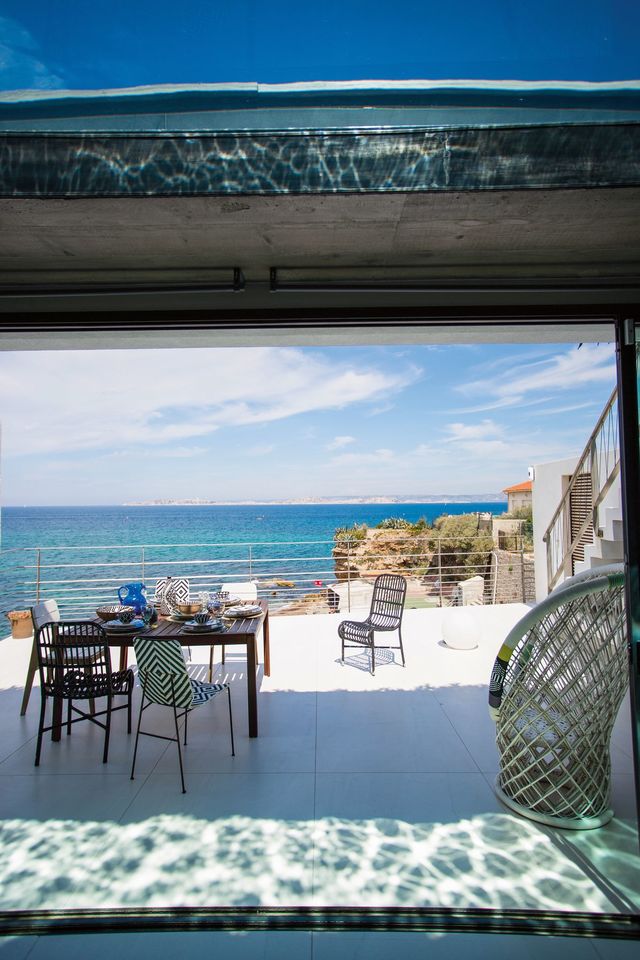 Comme le prolongement de la pièce de vie, cette grande terrasse avec vue mer joue volontairement avec les reflets de l'eau.